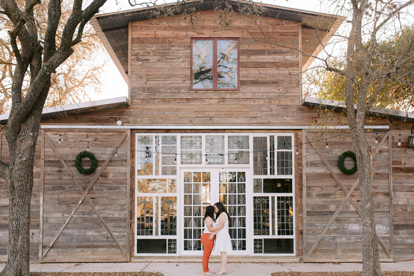 Stephanie and Bianca kissing before their wedding venue at Harper Hill Ranch